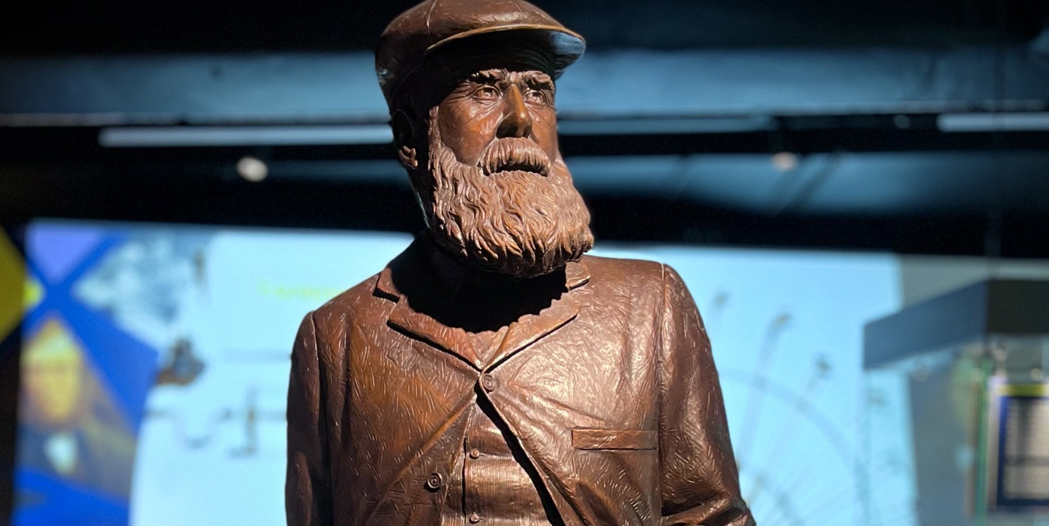 Estatua de Old Tom Morris, con gorra y barba, en una exhibición de historia del golf